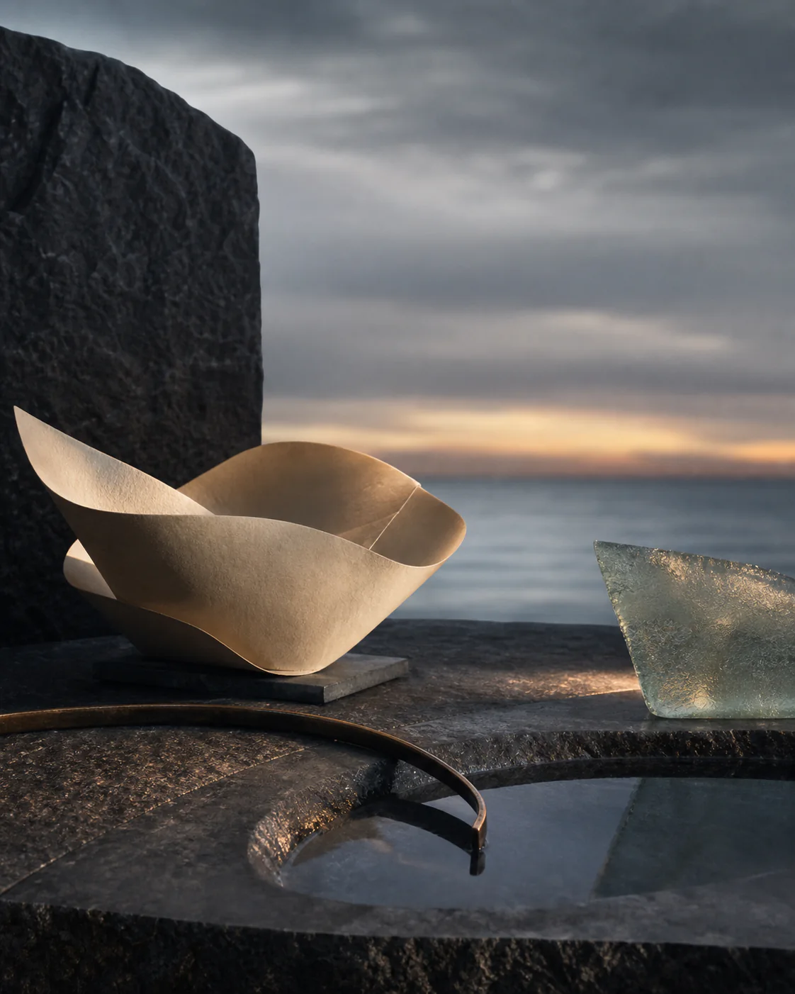 Abstract fictional material ritual with folded paper, dark mineral stone, sea glass, and water